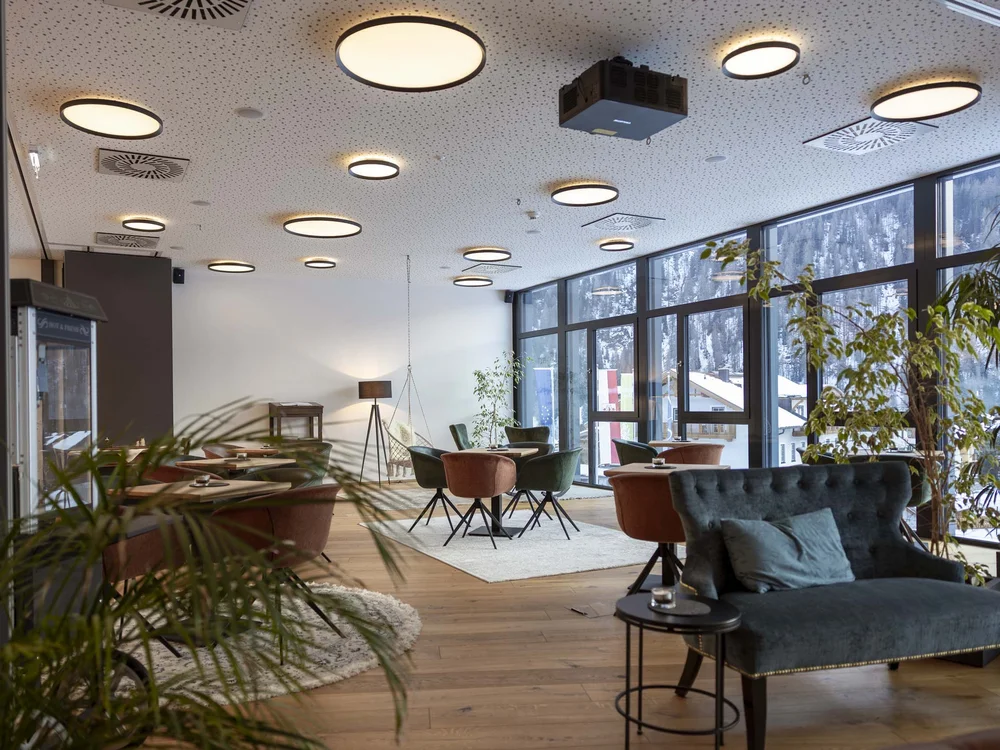 Interno di una sala moderna con grandi finestre e luci rotonde a soffitto