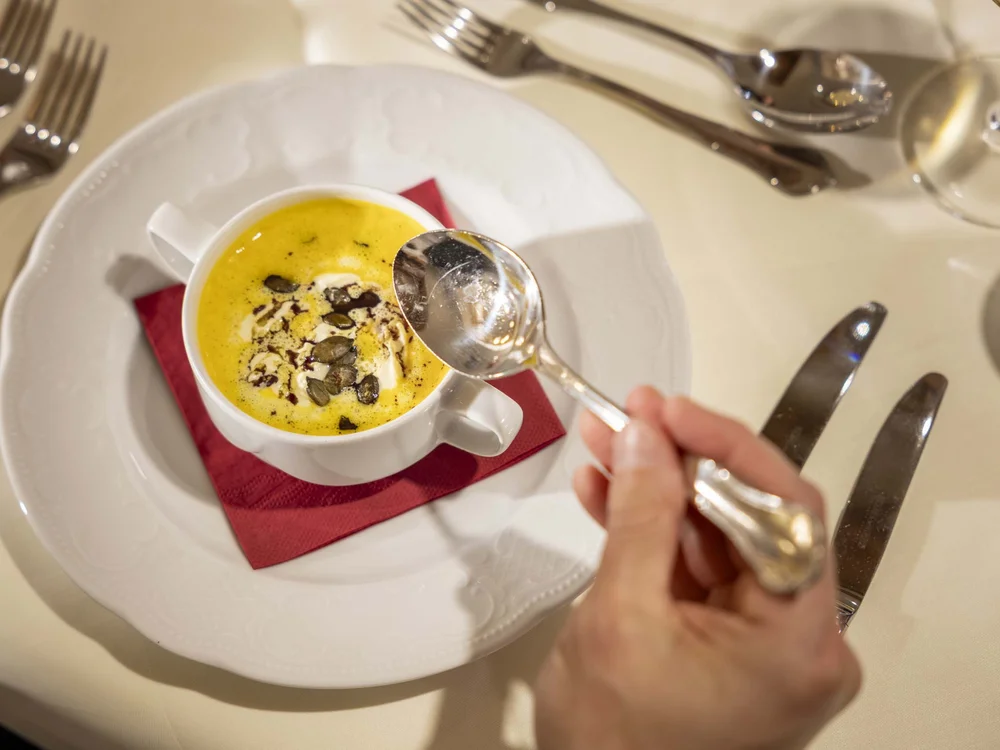 Zucca e crema caffè servite in tazza bianca con semi e cucchiaio