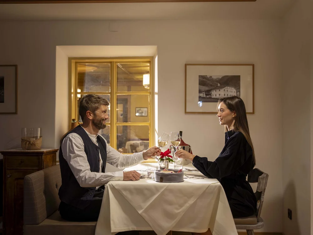 Coppia che brinda con vino bianco in un ristorante accogliente