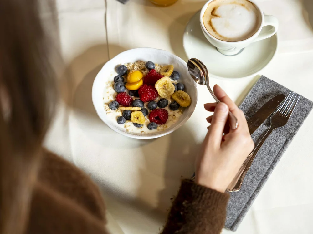 Colazione con frutti di bosco, banana e cappuccino