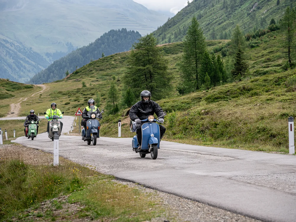 Gruppo di persone in moto su strada montana panoramica