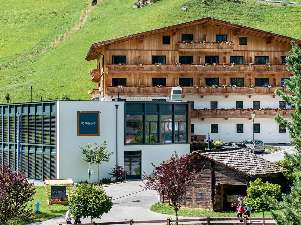 Hotel di montagna con balconi in legno e prato verde