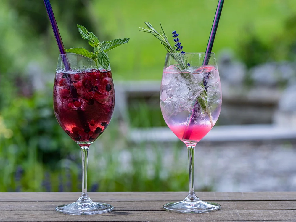 Due cocktail decorati con erbe fresche su tavolo di legno all'aperto