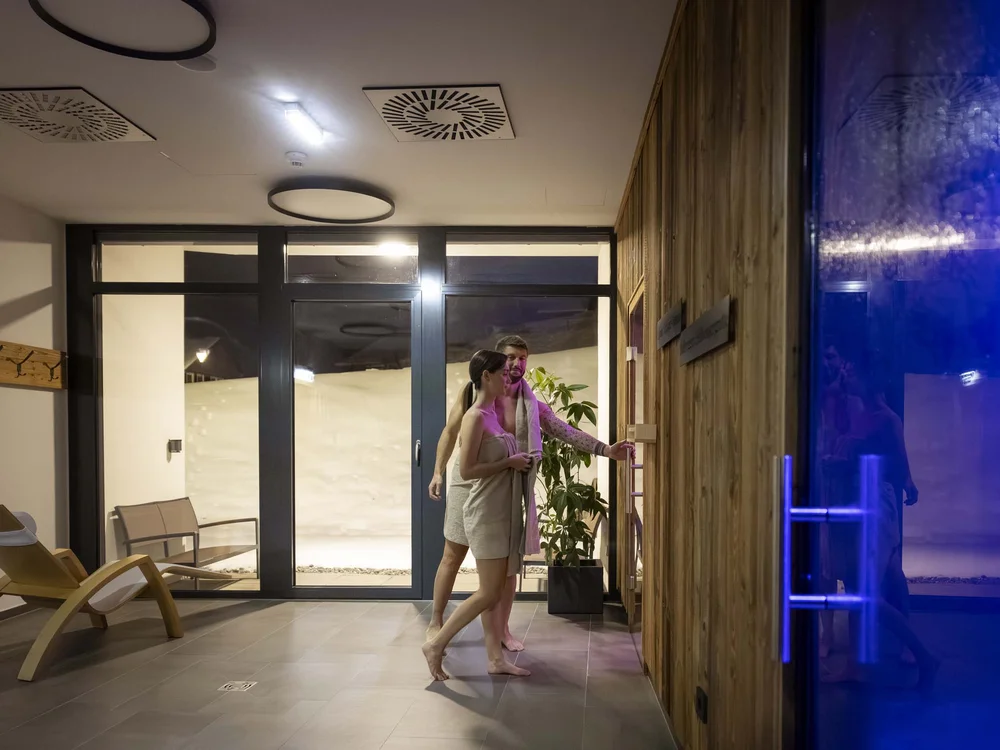 Coppia in accappatoio davanti a una sauna interna