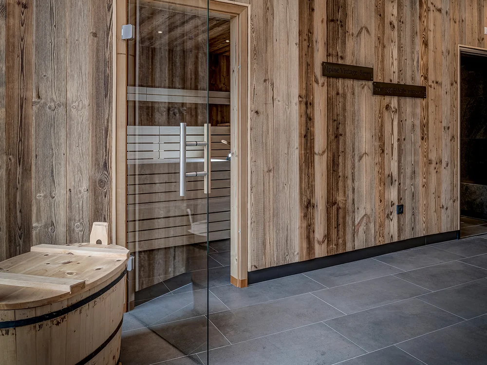 Ingresso sauna in legno con porta in vetro e vasca di legno